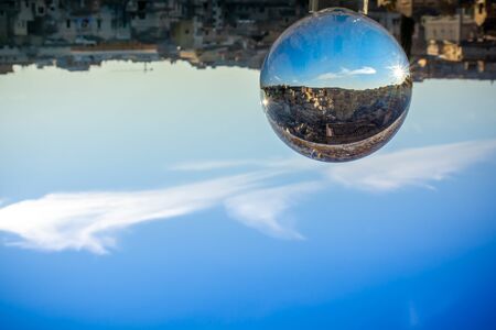 The Sassi of Matera enclosed in a Cristal Sphere on blue Sky Backgroundの写真素材