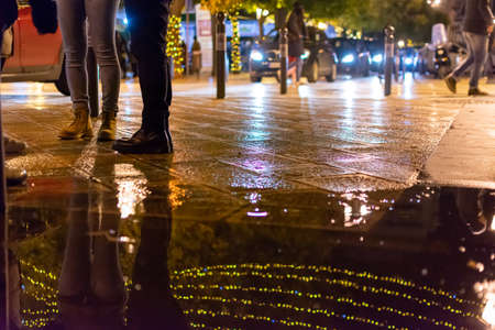 Close up of Chain of Lights reflected on Water on the Street in Holiday period, on Blurred...
