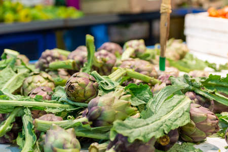 Close Up of Group of Artichokes at the Italian market on Blurred Backgroundの写真素材