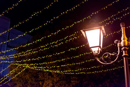 Close up of Chain of Lights reflected on Water on the Street in Holiday period, on Blurred Backgroundの写真素材
