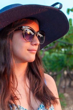 Close Up of Nice Teenager dresssing Blue Summer Hat and Glasses on Blurred background at Golden Hourの写真素材