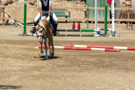 Close up on Start Signage on Blurred girl that rides a Pony during Pony Game Competition at the Equestrian Schoolの写真素材