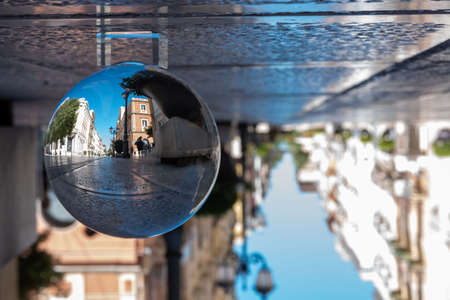 The D'aquino Street in the center of the town of Taranto, in the South of Italy, reflectdd into a...