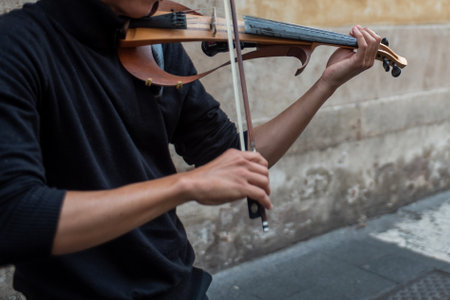 Close Up Of A Hand Playing Violin In The Street on Blurred Background