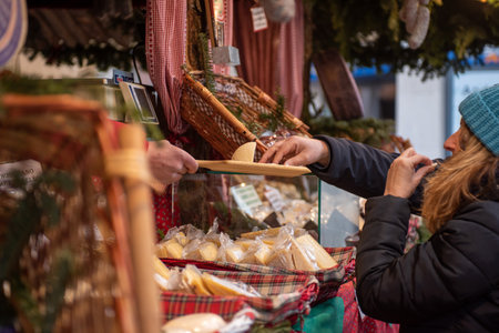 People Tasting Traditional Cheese Sold In A Christmas Market On Blurred Backgroundの写真素材
