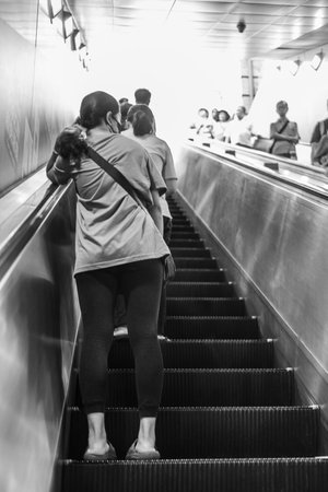 People On Escalator Inside The Underground Of Tokyo In Gray Scale On Blurred Backgroundの写真素材