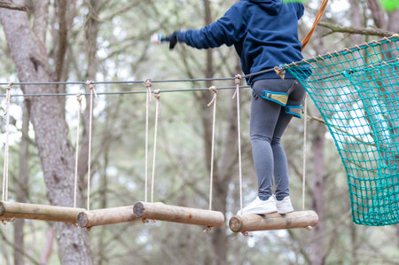 Girl Performing Adventure Path In The Adventure Park In The Forest On Blurred Background