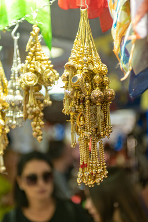 Selling Of Golden Asian Earrings Hanged In A Stall At The Market On Blurred Backgroundの写真素材
