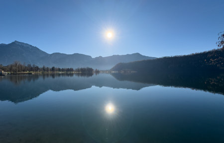 The Caldonazzo Lake With Reflections Of The Mountains In A Quiet Winter Day On Blue Sky Backgroundの写真素材