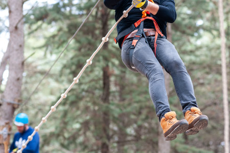 Girl Performing Adventure Path In The Adventure Park In The Forest On Blurred Backgroundの写真素材