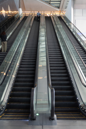 Man On Long Escalator Into the Airport On Blurred Background