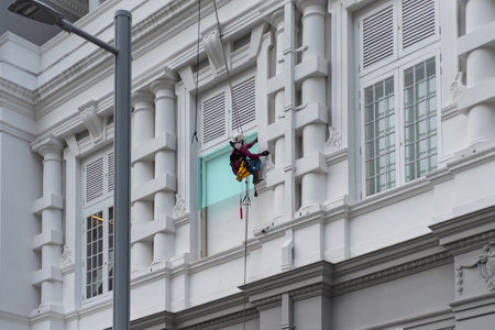 Person At Work Harnessed On A Building On Blurred Backgroundの写真素材