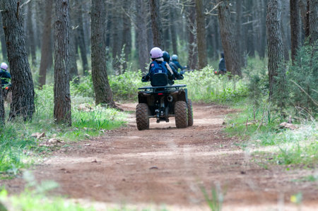 Children Riding Quad In The Forest On Holiday Period On Blurred Backgroundの写真素材