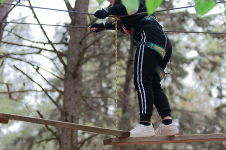 Girl Performing Adventure Path In The Adventure Park In The Forest On Blurred Background