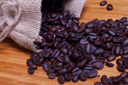 Coffee background - Sack of coffee grains against wood background