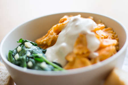 Pasta with white cashew based sauce and red tomatoes sauce with sauteed spinachの写真素材
