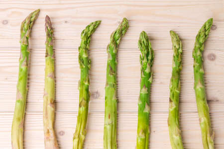 Fresh green asparagus shoots pattern, top view. Isolated over white. Food background asparagus flat lay patternの写真素材
