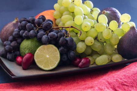Still life with grapes, figs, lime, peach mango and watermelonの写真素材
