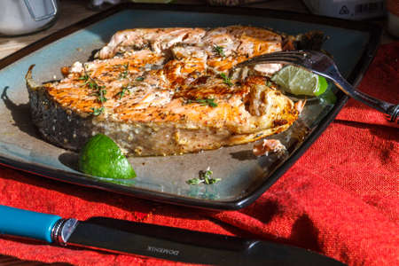 Delicious salmon steak grilled with lemon on a plateの写真素材