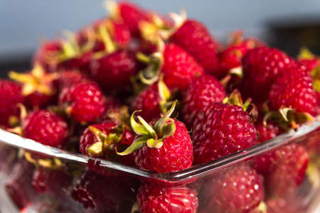 Red ripe raspberry fruit in transparent glass, macroの写真素材