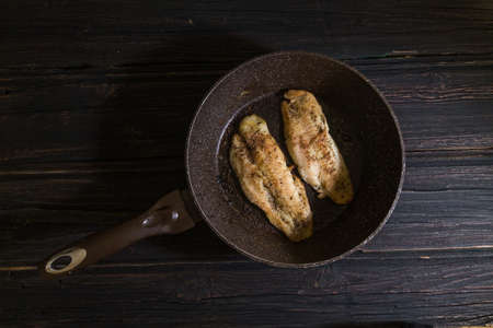 Frying pan with delicious fish on pan wooden backgroundの写真素材