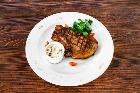 pork chop with vegetables in a white plateの写真素材