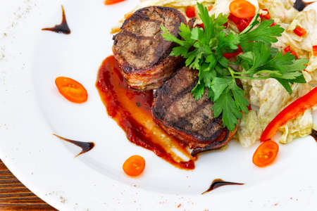 Juicy beefsteak minion from medium rare beef with a sauce on a white plate.の写真素材