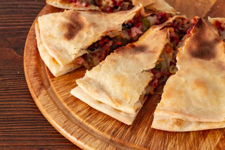 Pizza calzone on the textured table, for the restaurant menu, cafe, advertising.の写真素材