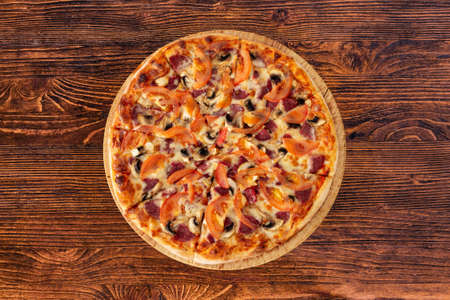 Bavarian pizza with sausages and mushrooms, juicy tomatoes and Parmesanの写真素材