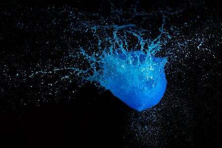 Blue liquid paint exploding in the air with a black backgroundの写真素材