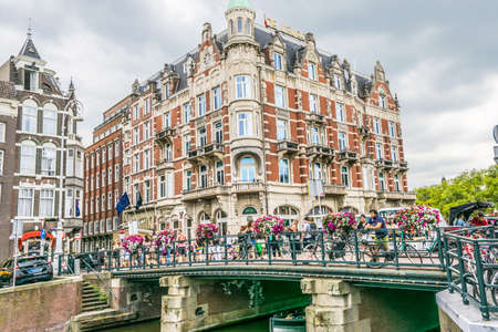 Amsterdam, Netherlands - July 18, 2018: Picturesque traditional Dutch houses and a bridge on the...