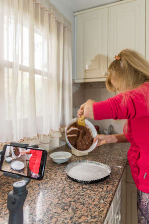 Adult female wearing a face mask to protect herself from the coronavirus. Shes filmed in her kitchen...