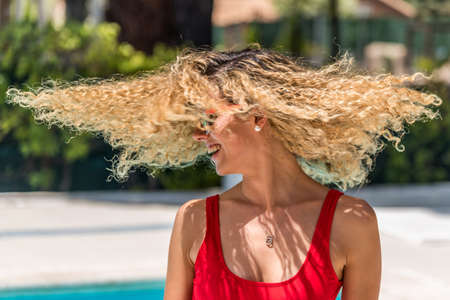 Blonde woman with curly hair and sunglasses shaking her headの写真素材