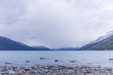 Panoramic view of Lake Argentino with a cloudy sky above itの写真素材