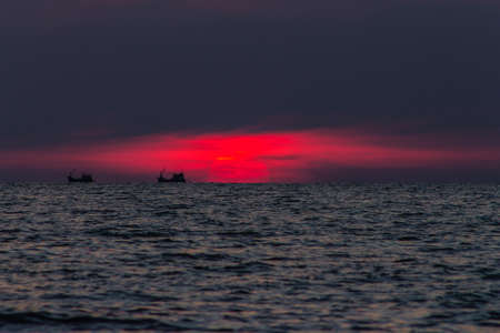 Amazing beautiful wide orange colorful sunset in Thailand Ko Lanta Island, Boat, burning sky, Beach, sun, sea, stones, sky, clouds, wallpaper, water sand oceanの写真素材