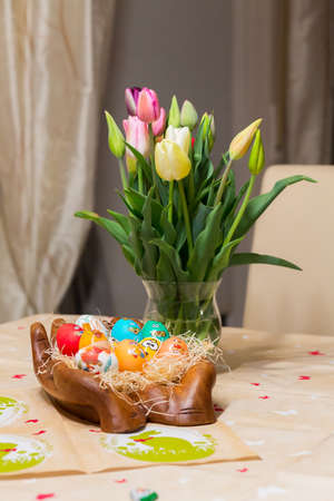 Easter holiday with colored eggs and flowers. colorful tulips near the painted Easter eggs of...