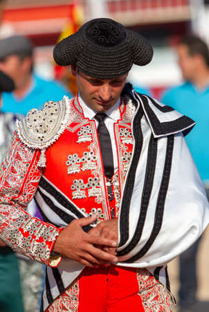 a Spanish bullfighter with a red dress in a bullfight in summerの写真素材
