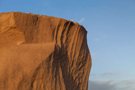 A closeup shot of a rock in the desert under the blue sky