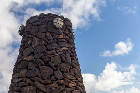Garden lamp on the top of a stone wall against the sky