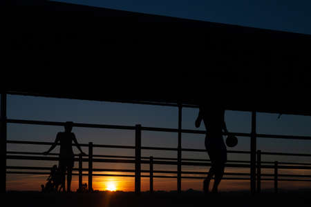 Silhouette of people playing soccer at sunset.の写真素材