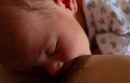 an adorable baby breastfeeding his motherの写真素材