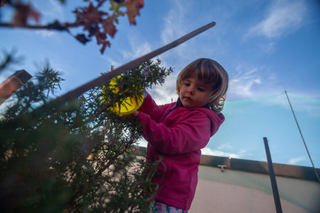 Cute Toddler in Purple Watering Garden Plants.の写真素材