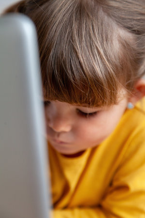 Real Little girl using a laptop computer, close-up, shallow depth of fieldの写真素材