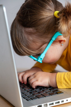 Real Cute little girl using a laptop computer at home. Education concept.の写真素材