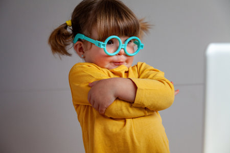 Portrait of a Real cute little girl wearing glasses and a yellow shirtの写真素材