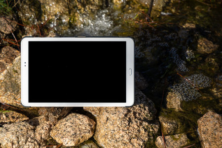 White tablet pc with black screen on stone background.の写真素材