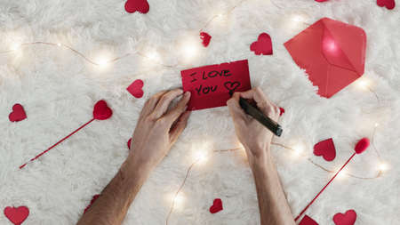 Boyfriend write a letter for valentines day on the white carpet. Vertical shoot.の写真素材