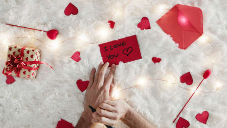 Boyfriend write i love you for valentines day on the white background. Vertical shoot.の写真素材