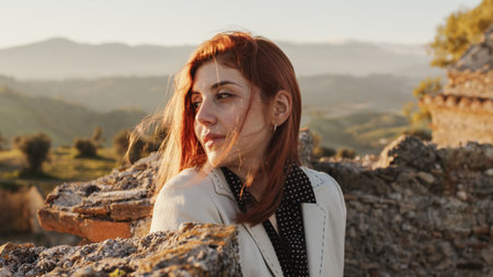 Beautiful girl with white dress explores an ancient Italian castle at sunsetの写真素材