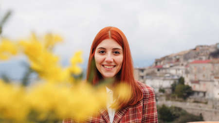 Young girl celebrates womens day with yellow mimosa flowers in handの写真素材